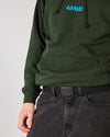 4Msb webbing belt in black and 4Msb hoodie in forest green seen on skater.