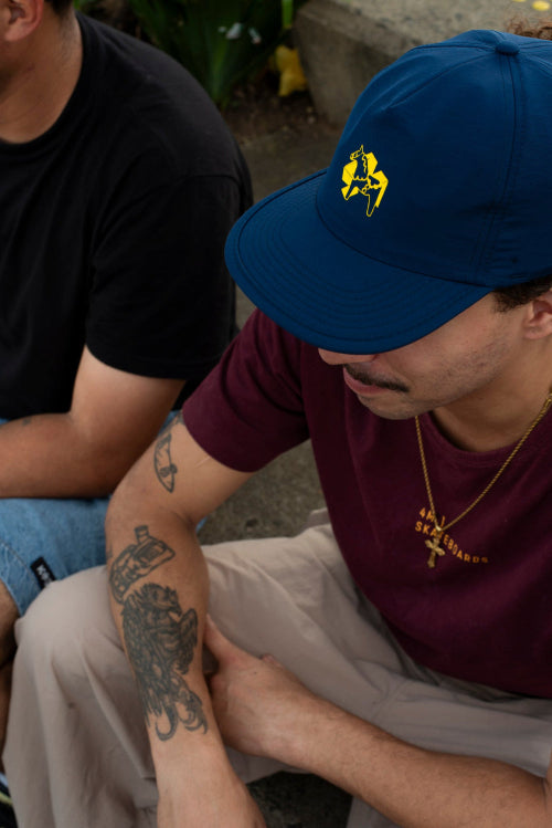 4Msb skaterboarder Hadriel Junior wearing a 4Msb cap in colour navy blue with a yellow dala horse 4Msb logo on the front