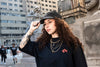 Young woman in a black outfit wearing a 4Msb 5-panel cap Kilian Zehnder tgraffiti in black with white texting