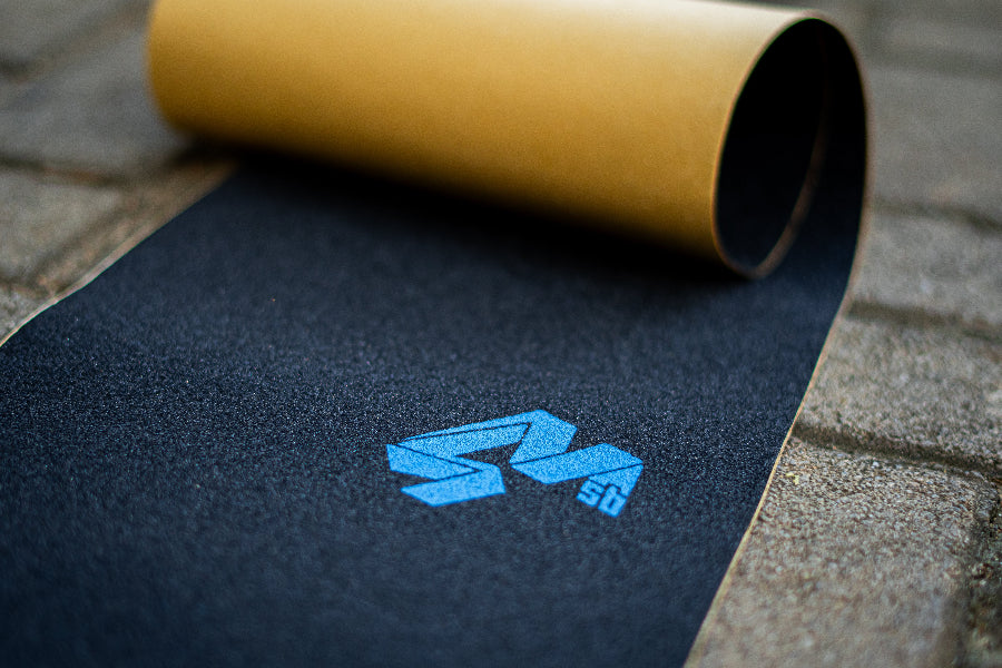 4Msb griptape black with the Quatro logo in blue on the pavement