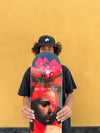 4Msb skateboard deck Bromeila with TIPtech, pro model for pro skateboarder Bruno Vinicius. The pro skater Bruno Vinicius is holding the deck in front of him, a yellow wall behind him. The graphic is red, black and white with a woman's face and the flower bromelia. Bruno is wearing a black 4Msb skateboard cap Quatro with a white 4Msb logo on the front. 