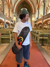 Pro skater Bruno Vinicius standing in the Oscar church in stockholm, sweden, with his 4Msb skateboard deck saint bridget, part of the saints collection.