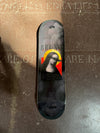 A 4Msb skateboard deck, part of the saints collection, photographed on the church floor. The graphic is dark grey and has an image of Saint Bridget with the title Bruno Vinicius.