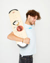 A skateboarder holding up a 4Msb skateboard deck Water Lily with TIPtech. He is wearing a ice blue 4Msb t-shirt dala horse and dark jeans.
