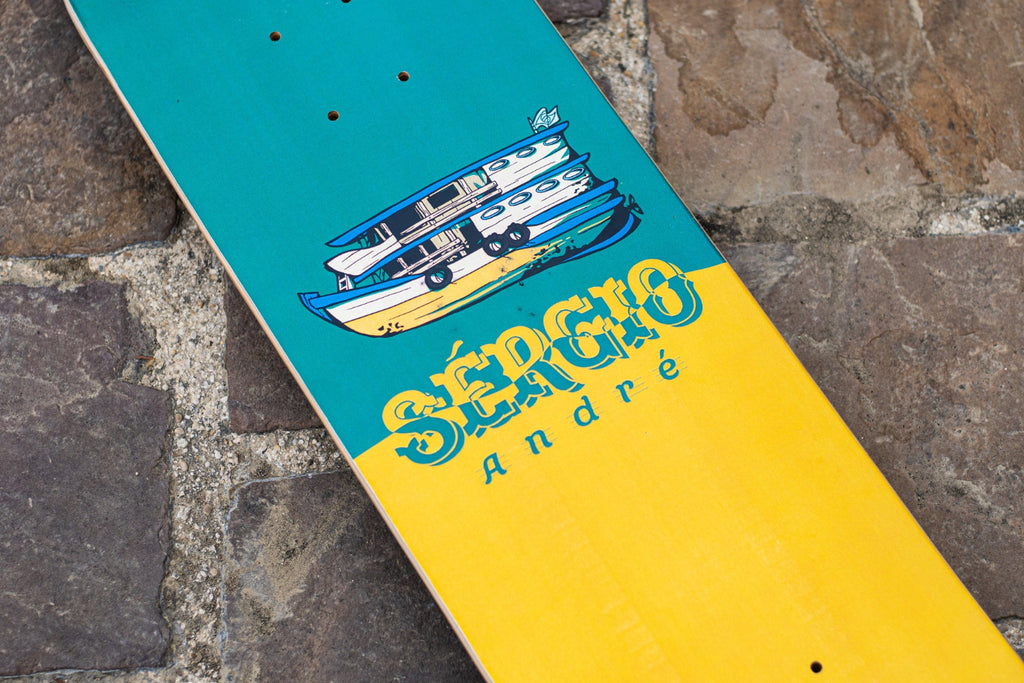 Pro rider Sergio Andre signature skateboard deck with a green and yellow graphic and a depiction of a fishing boat.