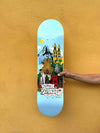 Pro skater Kilian Zehnder showing his new pro model, skateboard deck 'cities' classic shape (without TIPtech) against a yellow wall. The graphic of the deck has a light blue background, small yellow sun and skylines, mountains, towers, palm threes illustrating Kilian's four favorite cities.