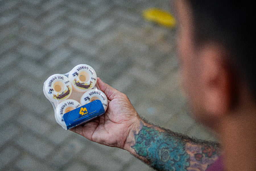 4Msb pro rider Rodrigo Leal showing his signature skateboard wheels 4 pack Drakkar Rodrigo Leal 53mm, white with drakkar boat in brown and gold and text in black.