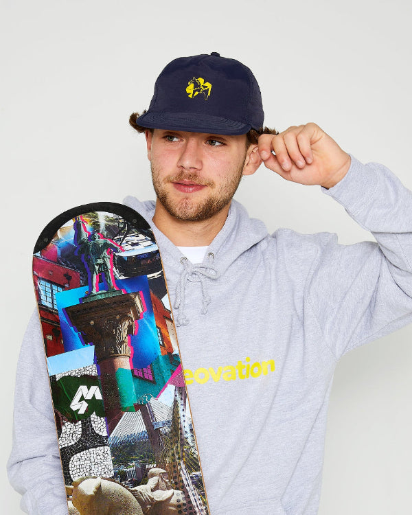 skatboarder wearing navy blue snapback cap with a yellow dala horse on the front and a grey skateovation hoodie, holding a 4Msb skateboard deck Collage Engelbrekt with TIPtech.