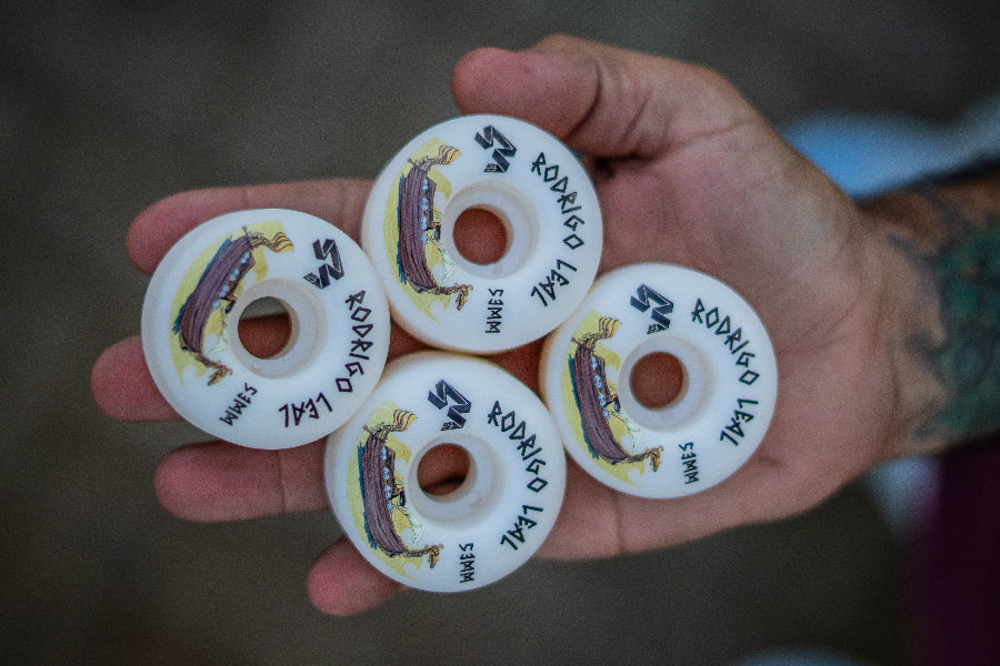 4Msb pro rider Rodrigo Leal showing his signature skateboard wheels 4 pack Drakkar Rodrigo Leal 53mm, white with drakkar boat in brown and gold and text in black.