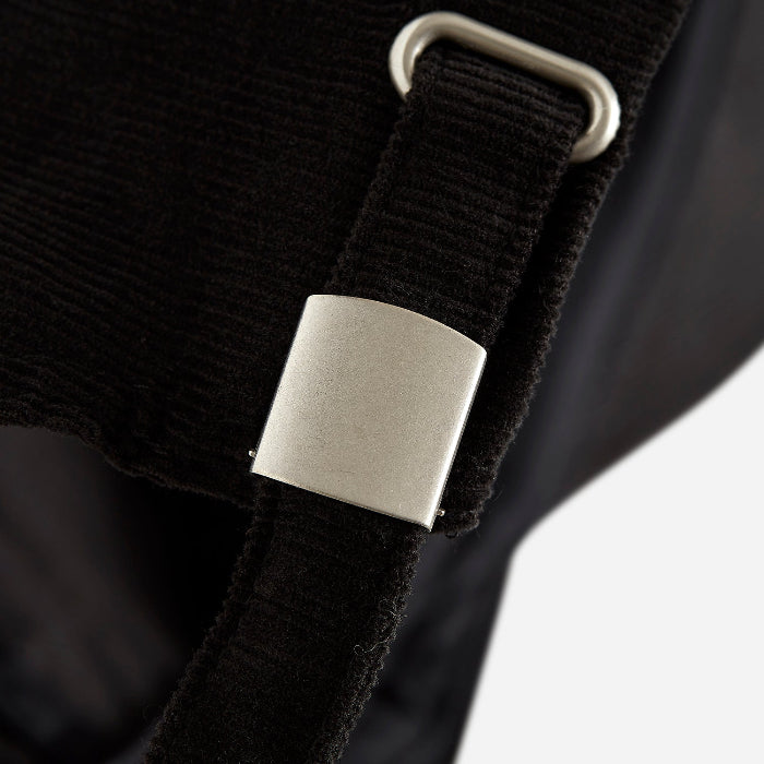 4Msb corduroy cap Quatro in black. Close-up of the strap with silver effect buckle and grommet.