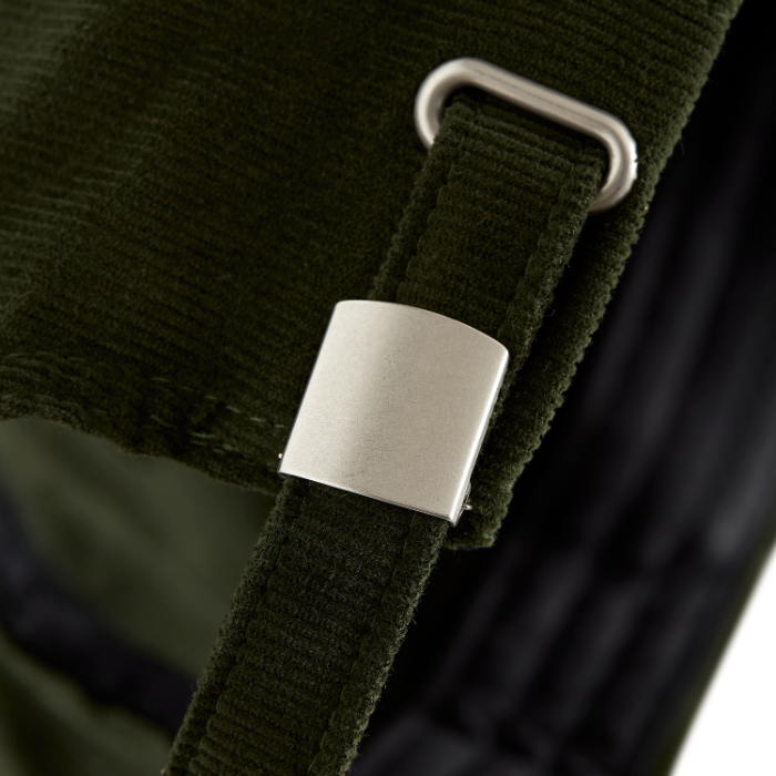4Msb cap corduroy Quatro in the color olive green, close-up on the self-fabric strap with silver effect buckle and grommet on the back.