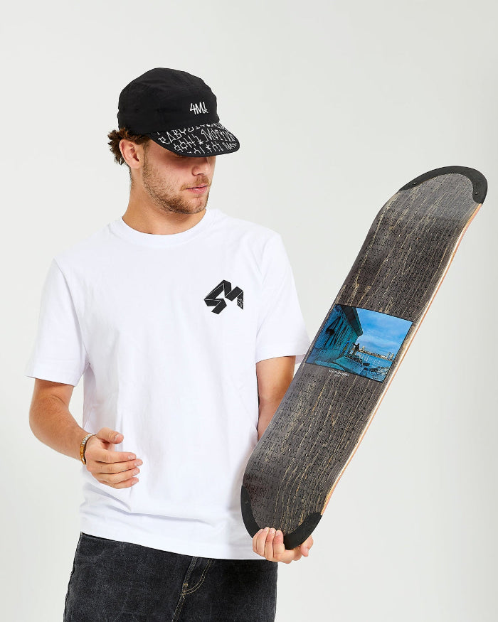 skateboarder wearing black 4Msb cap kilian zehnder graffiti, white t-shirt with 4Msb logo, holding a skateboard deck Kilian Zehnder graffiti with TIPtech.