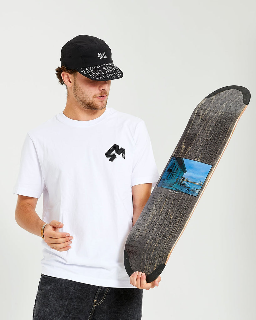 skateboarder wearing black 4Msb cap kilian zehnder graffiti, white t-shirt with 4Msb logo, holding a skateboard deck Kilian Zehnder graffiti with TIPtech.