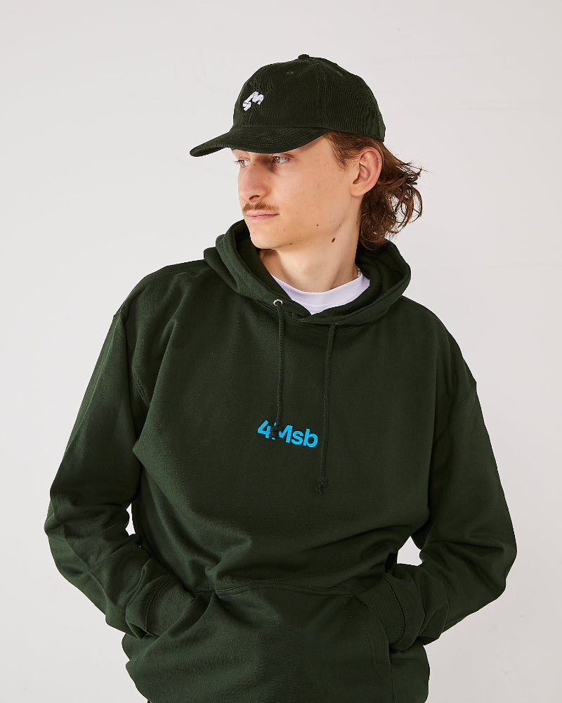 Skater wearing a olive green 4Msb corduroy cap Quatro and a matching forest green 4Msb hoodie.