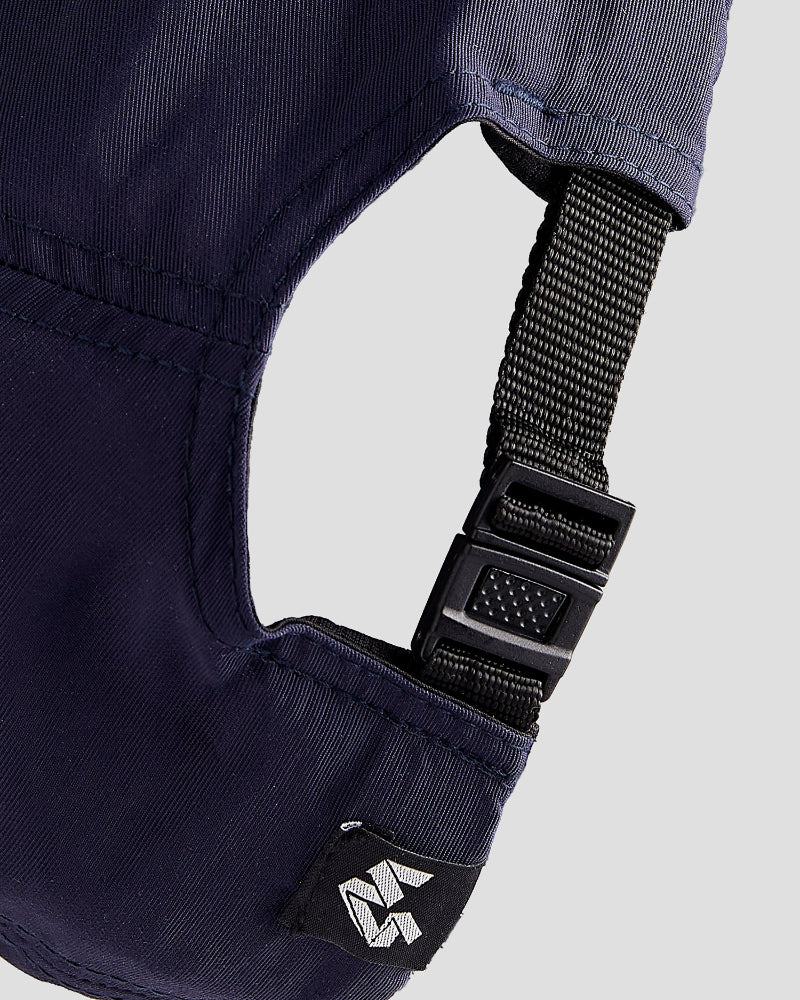 Close-up of a navy blue dad cap, the back, showing a black strap and a small 4Msb logo