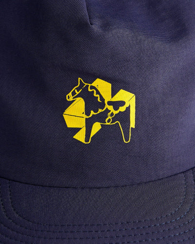 Close up on a the front of a navy blue dad cap with a yellow 4Msb logo with a yellow dala horse