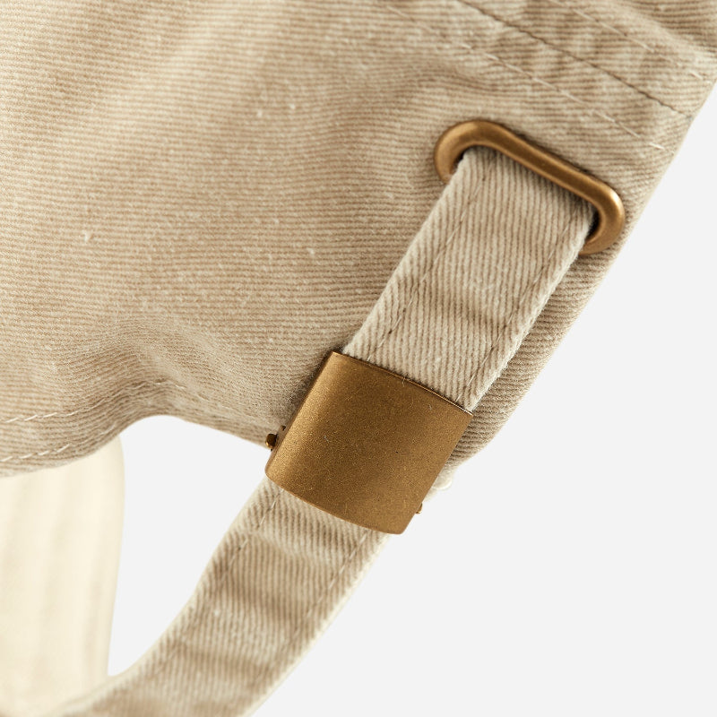 Close-up of sand coloured dad cap dala horse with strap and brass buckle.