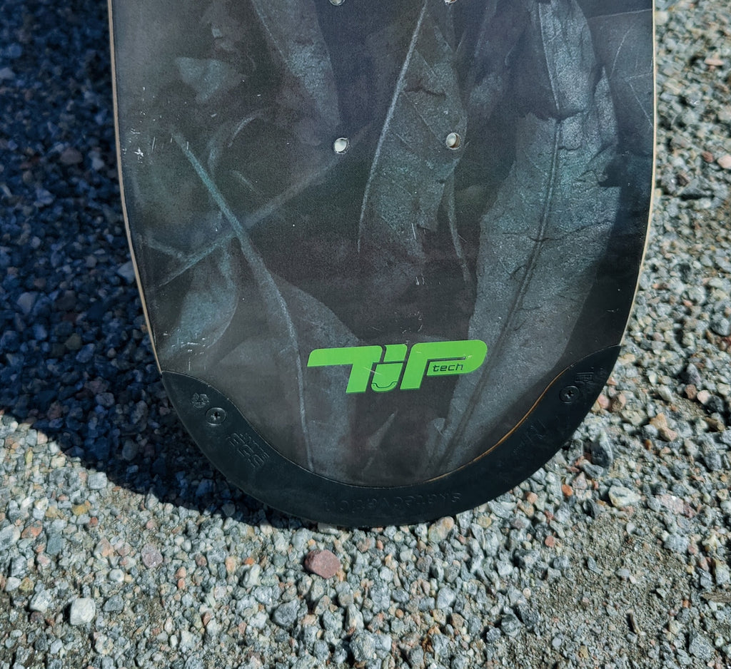 Close-up of the 4Msb Curupira skateboard deck with TIPtech. Detail photo showing the 'TIPtech' logo in green and on tip.