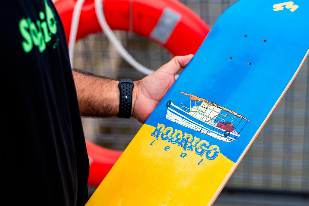 4Msb Pro rider Rodrigo Leal holding a skateboard deck with a blue and yellow design.