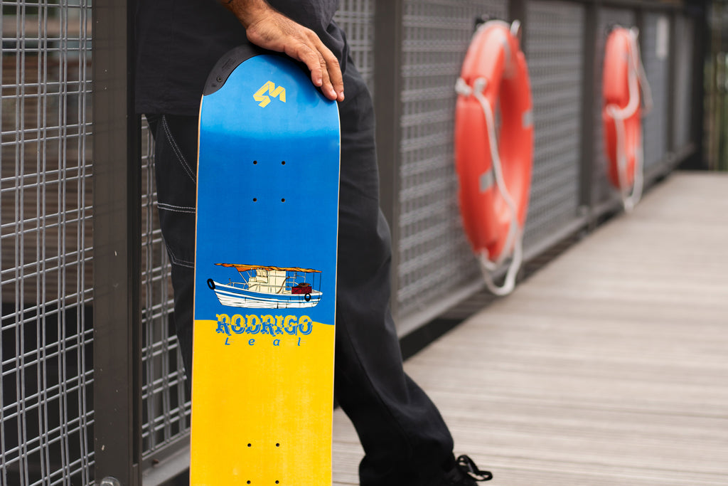 4Msb Pro skater Rodrigo Leal with his signature deck Fisher TIPtech, boat collection, standing on a bridge.
