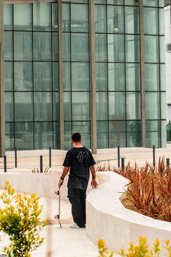 Pro skate Rodrgio Leal in Lisbon wearing black 4Msb T-shirt and holding his skateboard deck.