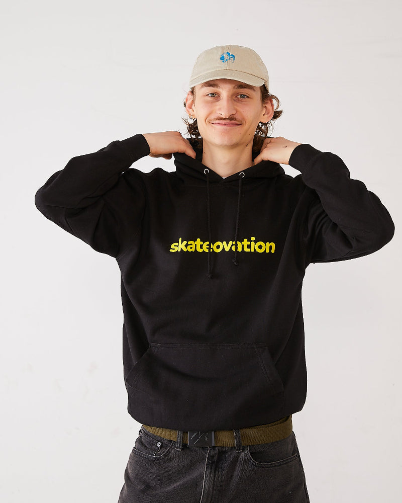 Skater wearing a black hoodie with 'skateovition' text and a beige 4Msb dala horse dad cap.