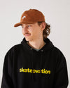 Skater wearing a black skateovation hoodie core and a 4Msb camel brown corduroy cap Quatro.