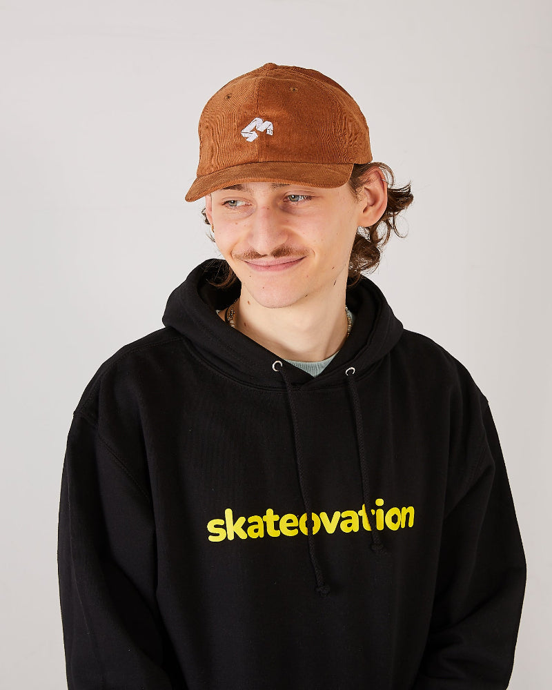 Skater wearing a black skateovation hoodie core and a 4Msb camel brown corduroy cap Quatro.