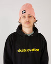 Skateboarder wearing 4Msb cuffed beanie quatro in colour blush and skateovation hoodie core black.