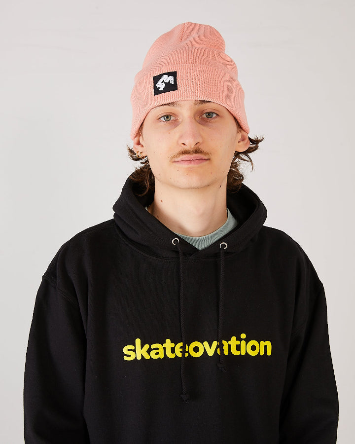 Skateboarder wearing 4Msb cuffed beanie quatro in colour blush and skateovation hoodie core black.