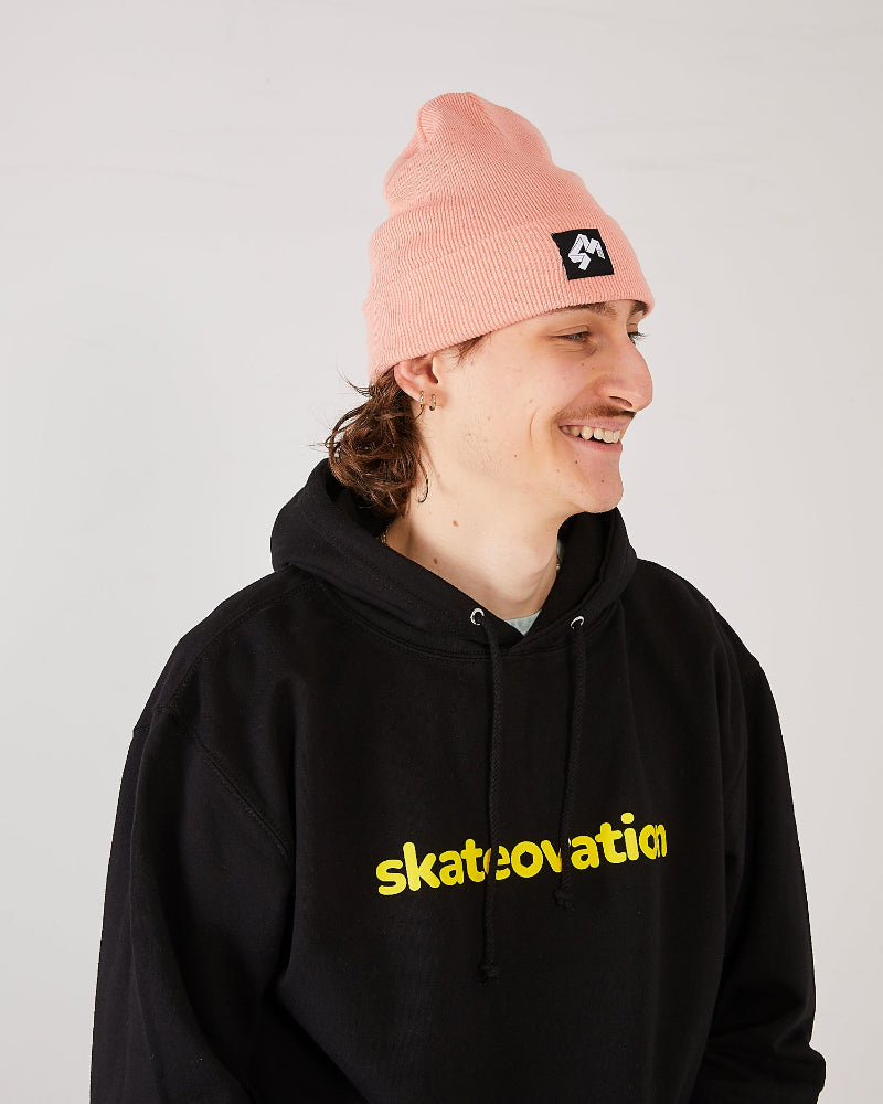 Skateboarder wearing 4Msb cuffed beanie quatro in colour blush and skateovation hoodie core black.