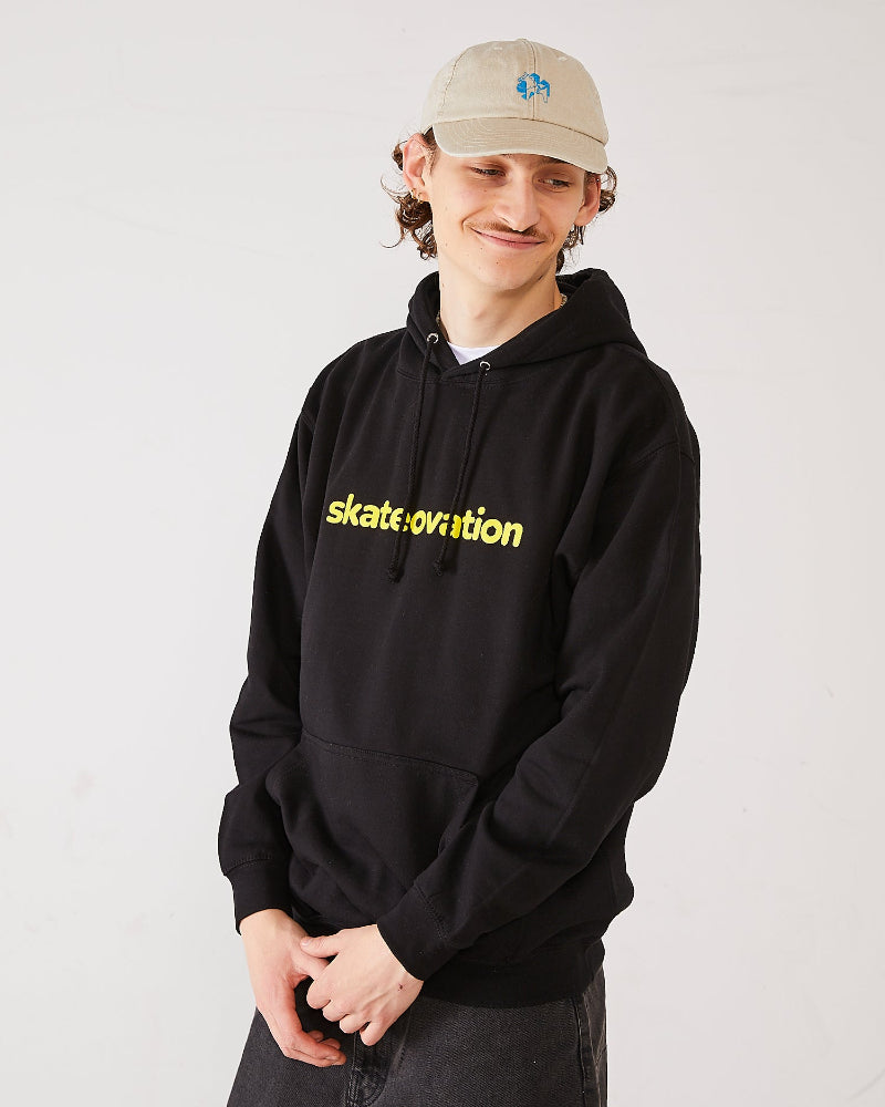 Skater wearing a black hoodie with 'skatevolution' text and a vintage sand coloured 4Msb dad cap dala horse.