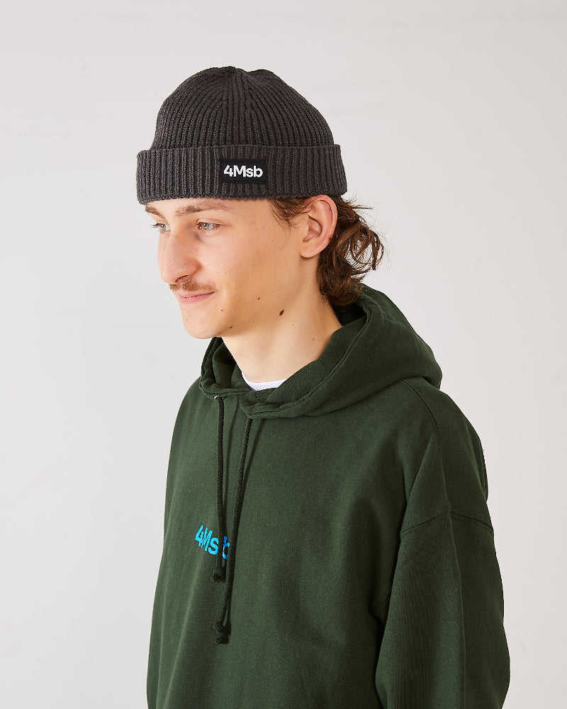 Skater wearing 4Msb fisherman beanie edge graphite grey and 4Msb hoodie forest green.