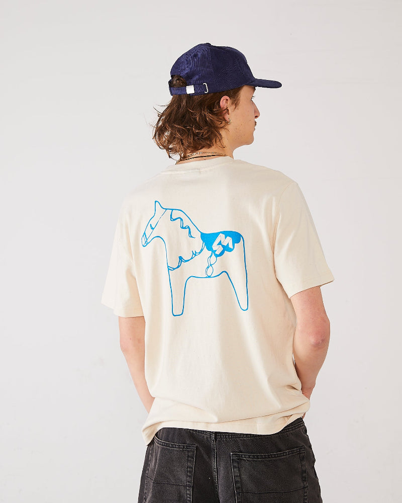 Skater wearing 4Msb T-shirt dala horse in the colour natural raw (back) and corduroy cap Quatro navy.