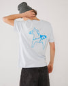 Skater wearing a light t-shirt with a blue dala horse on the back and a grey SO cuffed beanie.