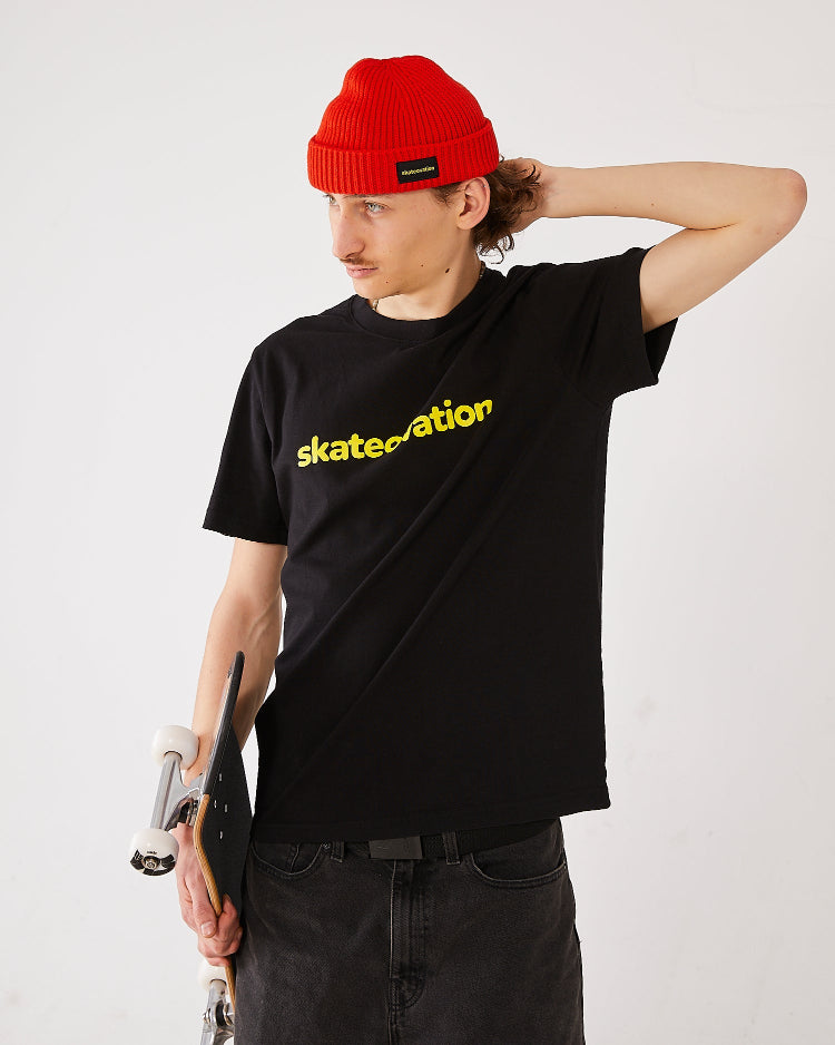 Skater wearing a black skateovation T-shirt Core  and a skateovation fire red harbour beanie core.