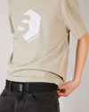Skater  wearing a beige skateovation t-shirt SO 720 stone and a black skateovation webbing belt SO with a black metal buckle.