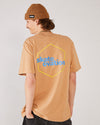 Skater seen from behind wearing the Skateovation SO Honeycomb t-shirt in colour latte with yellow honeycomb pattern on the back. skateovation written in blue at the center. Wearing a 4Msb fisherman beanie in the colour biscuit.