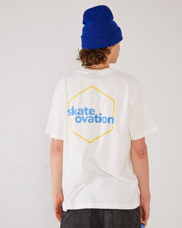 Skater wearing Skateovation SO Honeycomb T-shirt in off-white with a yellow honeycomb pattern on the back, and a royal blue Skateovation SO cuffed beanie.