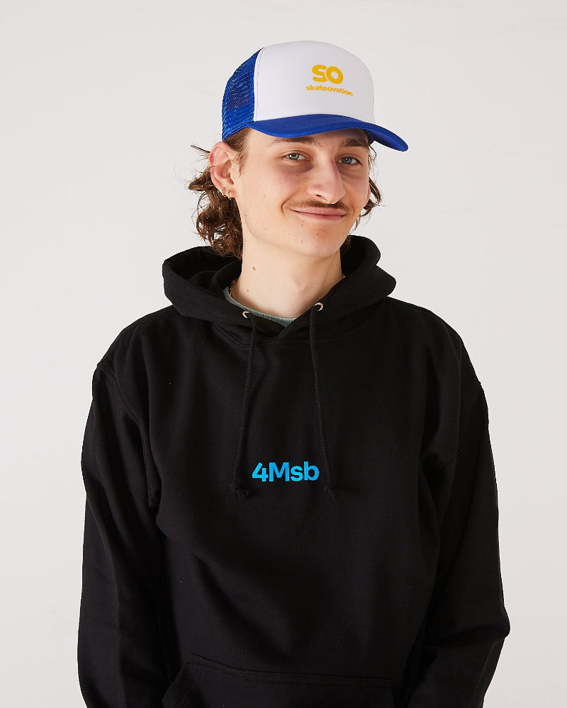 Skateboarder wearing a black 4Msb hoodie and a blue and white skateovation SO trucker cap.