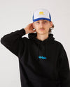 Skateboarder wearing a black 4Msb hoodie and a blue and white skateovation SO trucker cap.