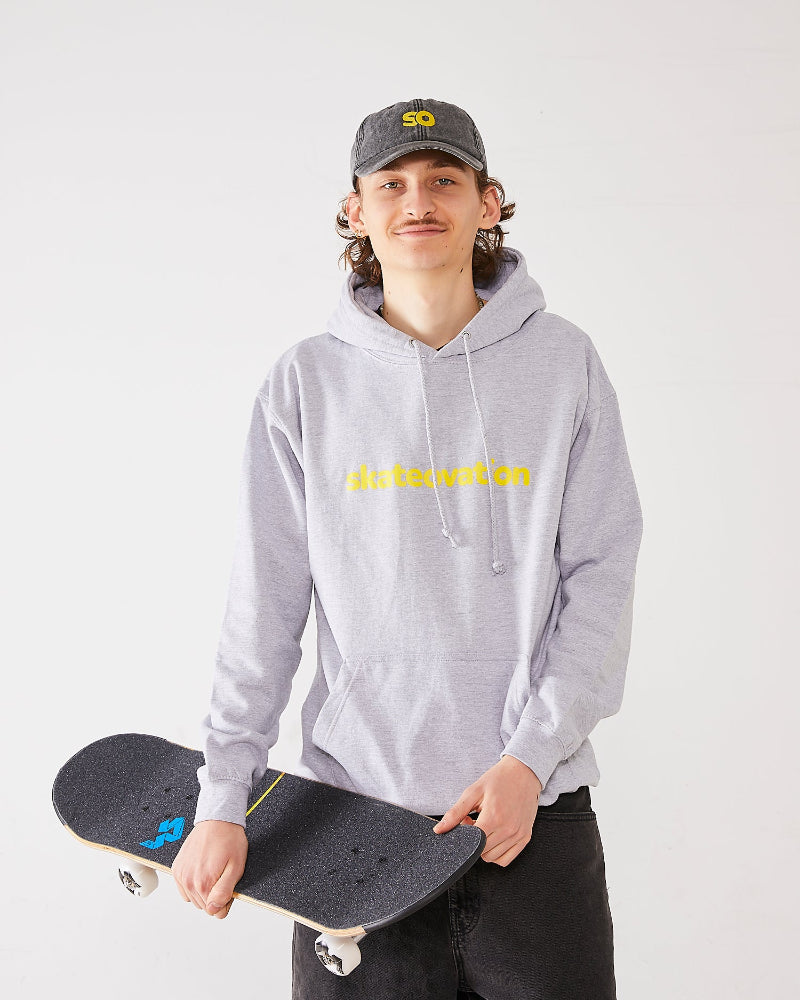 Skater wearing SO dad cap vintage black and a skateovation hoodie in color heather grey. Holding a skateboard  with 4Msb griptape and wheels.