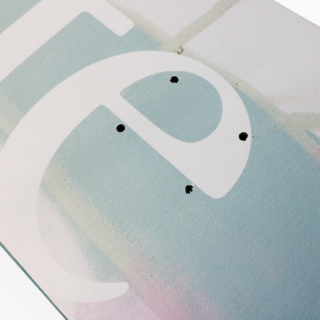 Close up of the Cafe Skateboard Deck JLH in Cream/Green, the deck graphic is are abstract pastel shades of green and cream with a large 'cafe' text on it.