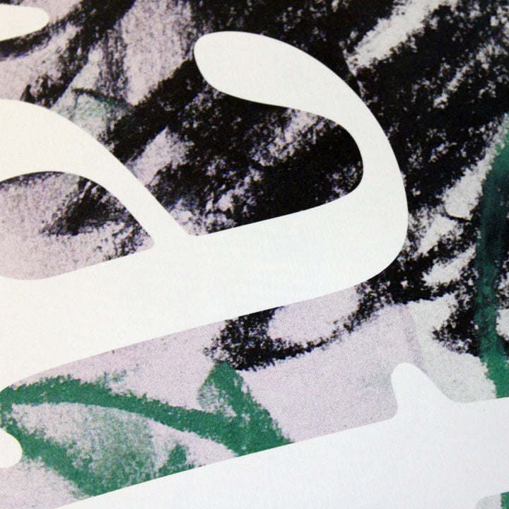 Close up of the Cafe Skateboard Deck JLH in Lavender/Green, a pastel lavender colored deck with abstract green and black scribbles on it as well as the word 'cafe' written in large.