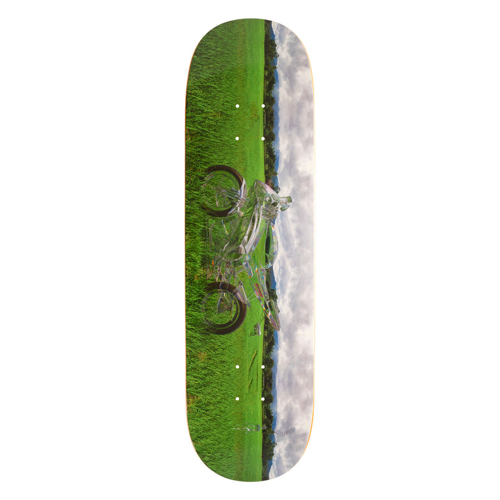 Sci-fi Fantasy skateboard deck with a green grass and blue sky graphic and a clear motorcycle.