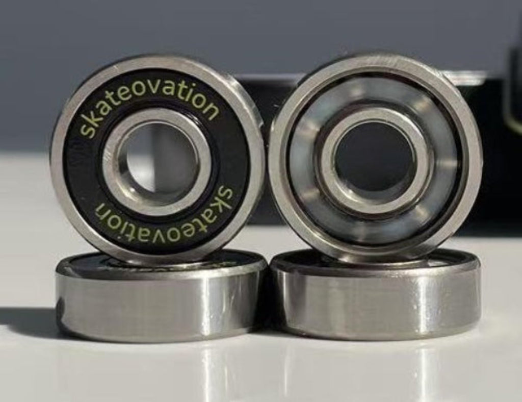 Skateovation skateboard bearings closeup of front, side and back of 4 bearings. Comes in set of 8 in a tin box.