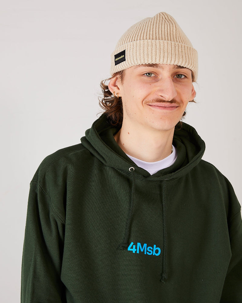skater wearing a forest green 4Msb hoodie and a oatmeal beige skateovation harbour beanie core.