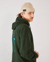 skater wearing a green 4Msb hoodie with a dala horse on the back and a beige skateovation harbour beanie oatmeal.