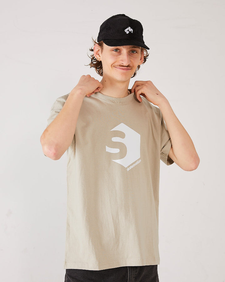 skateboarder wearing a beige skateovation t-shirt SO 720 stone and a black 4Msb cord cap quatro.