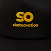 Black trucker cap, close-up in the yellow 'SO skateovation' logo on the front.